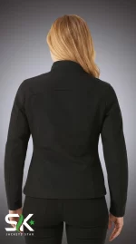 Rear view of a female model wearing our women's black softshell jacket with ergonomic back seams and articulated elbows.
