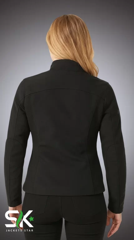Rear view of a female model wearing our women's black softshell jacket with ergonomic back seams and articulated elbows.