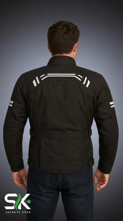 Rear studio view of a male model wearing an all-black textile motorcycle riding jacket with upper back white geometric striping and a cinch waist belt.