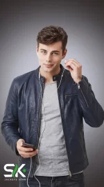 Front studio portrait of a model wearing our custom manufactured men's navy blue genuine leather cafe racer jacket with snap collar and zippered cuffs.
