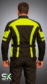 Studio back view of male rider wearing high-visibility yellow and black textile motorcycle jacket with waist cinch belt.