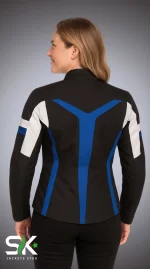 Back view of a female model wearing a fitted black textile motorcycle jacket with royal blue geometric overlays and white sleeve accents.