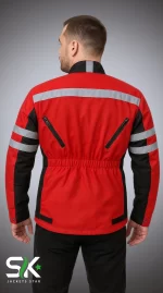 Studio rear view of a male model wearing a red and black textile motorcycle touring jacket with reflective back striping and dual exhaust zippers.