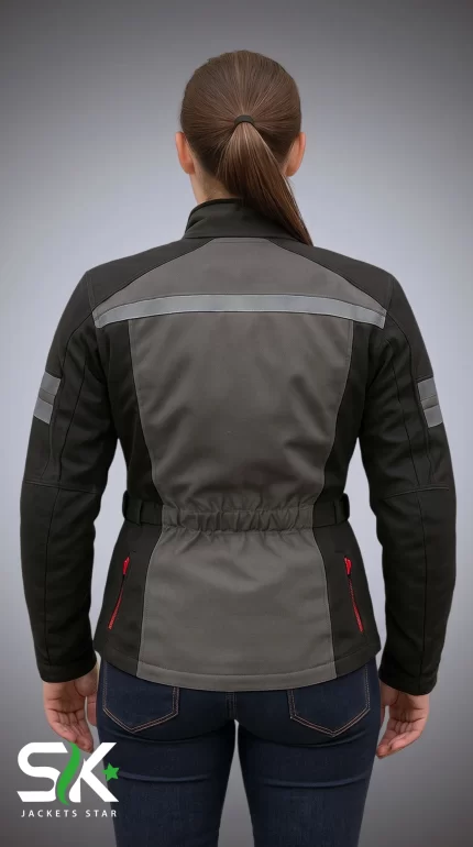 Rear perspective of a female model wearing our manufactured grey and black textile motorcycle riding jacket with high-visibility reflective striping and cinched elastic waist.