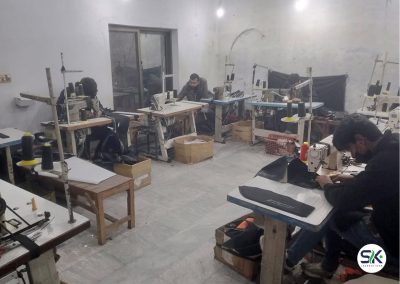 Skilled technicians at Sialkot Jackets Star operating industrial sewing machines to assemble custom jackets and technical apparel on the factory floor.