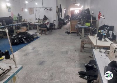 Skilled technicians at Sialkot Jackets Star operating industrial sewing machines to assemble custom jackets and technical apparel on the factory floor.