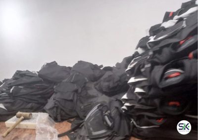 A large stack of completed black and grey technical jackets staged for final inspection and packaging at the SK Jackets Star manufacturing facility.