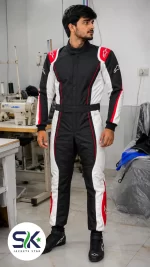 Male model standing in factory wearing black white and red Cordura go-kart racing suit made on demand in Sialkot.