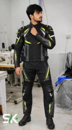 Front view of a male model demonstrating our manufactured two-piece textile riding suit featuring knee sliders and shoulder TPU protectors inside our factory studio.
