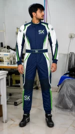 Male model standing in factory wearing navy blue white and green custom go-kart racing suit with chest logo made on demand in Sialkot.