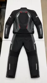 Flat lay rear view of a 2-piece black and grey Cordura biker suit with red accents and speed hump.