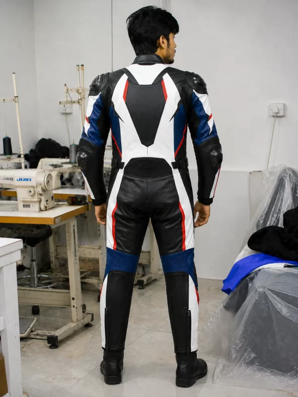 Rear view of a male model wearing a 1-piece top grain leather motorcycle racing suit with speed hump in a factory setting.