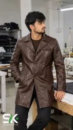 Front view of a male model wearing our custom manufactured brown leather car coat with notched lapels and button closure inside our stitching unit.