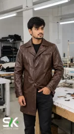 Front view of a male model wearing our custom manufactured brown leather car coat with notched lapels and button closure inside our stitching unit.